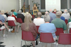 Sharon Hughes speaking before a full house Wednesday at the Charlottesville Senior Center.